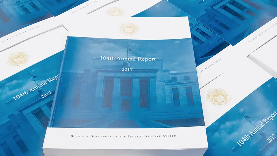 Printed copies of an annual report stacked on a table
