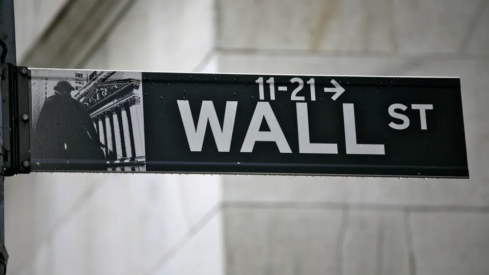 A Wall Street street sign against a stone building in New York