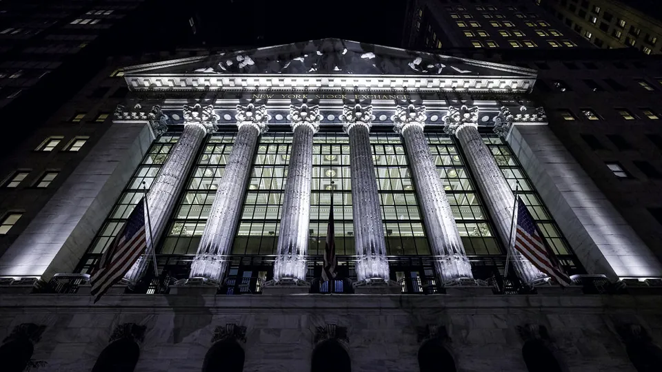 The New York Stock Exchange building lit up at night, after the regular trading session