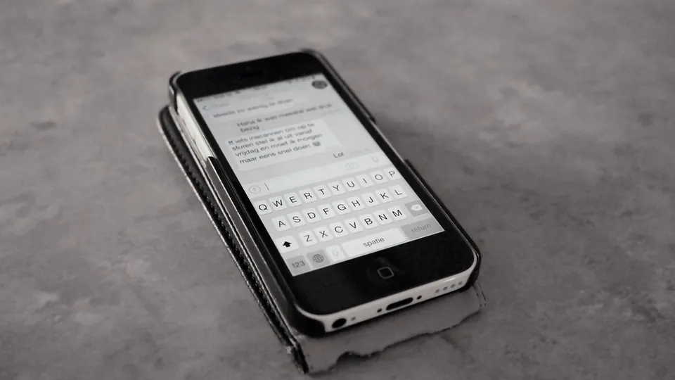 A smartphone showing a stream of text messages on a table