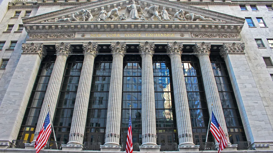 The columned facade of the New York Stock Exchange building on Wall Street, hung with American flags